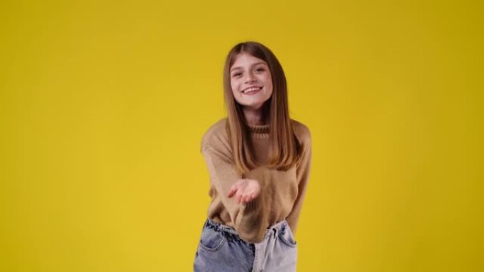 一个女孩在黄色背景上发送air kiss的4k视频。
