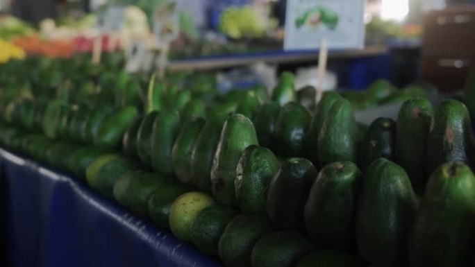 成熟的绿色鳄梨躺在农贸市场的柜台上。