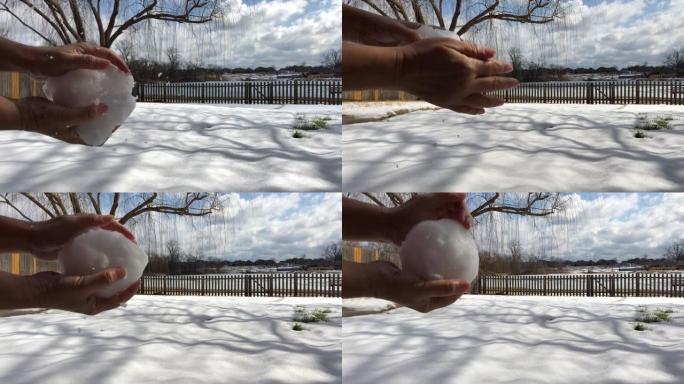 女人的手将雪块形成球