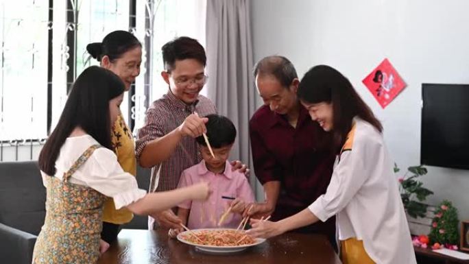 多代亚洲华人家庭庆祝春节传统美食娄桑 (生鱼菜)