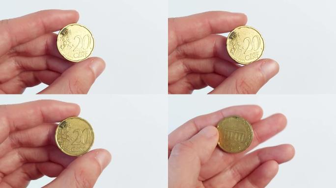 一只手拿着一枚20欧分的硬币。概念、金融、银行、经济
