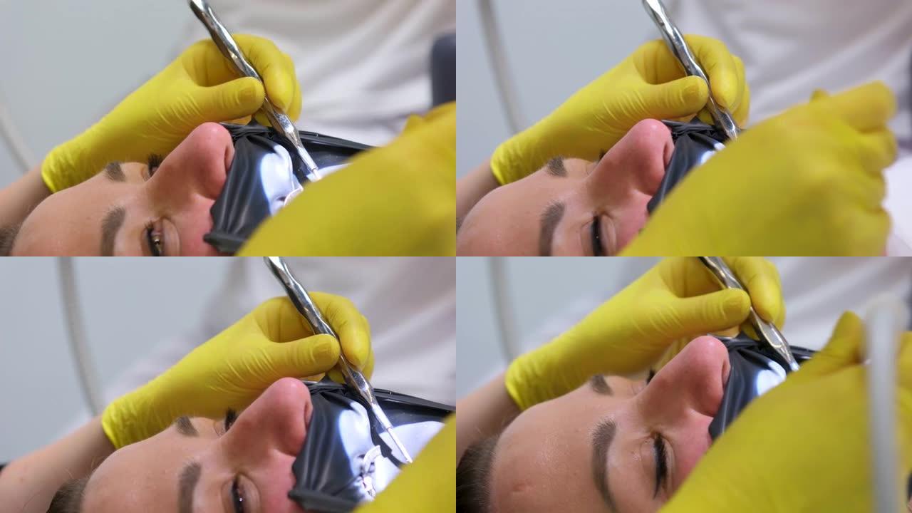 牙科预防龋齿的评论。牙科手术中牙医椅子上的一名妇女黄色清洗手套