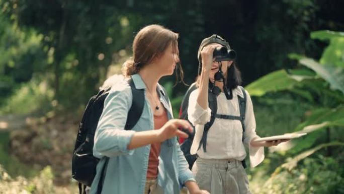 开朗的家庭徒步旅行者使用双筒望远镜在森林中寻找鸟类。