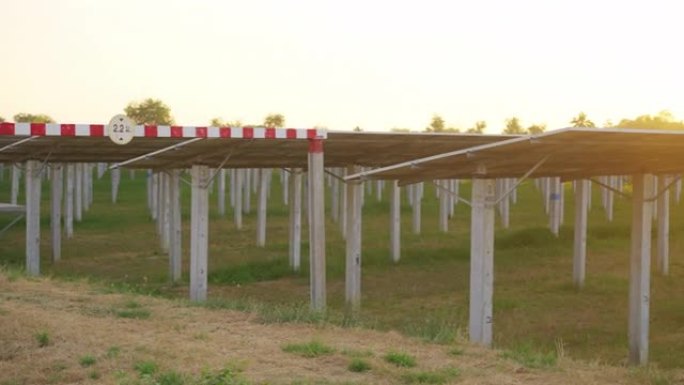 日落时从地面看产生清洁电力的太阳能电池板农场的视图