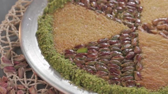 铜盘中的传统土耳其甜点kunefe。卡纳菲奶酪和开心果概念