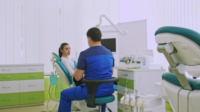 阿拉伯牙医告诉妇女坐在牙科椅上的病人有关卫生的信息。口腔的综合治疗。医学与健康