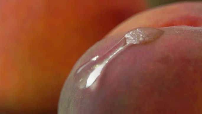 慢动作中流下多汁桃子的一滴水的超级特写
