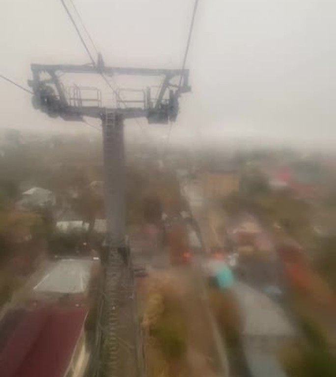下雨，阴天的秋日，从阿斯塔纳的缆车俯瞰城市。雾蒙蒙的城市景观的俯视图，工作日城市高速公路上的交通繁忙