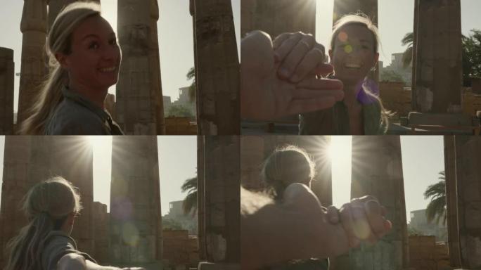 跟随我的概念: 年轻女子牵着男朋友的手带领着通往埃及美丽寺庙的路