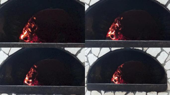 炉子里用来做饭的火的特写镜头。在金属炉子里烧火洗澡。冬天为房屋供暖的燃木炉
