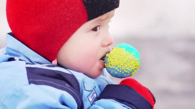 一个孩子在圣诞晚会上吃糖果。孩子们在圣诞节市场上吃糖果