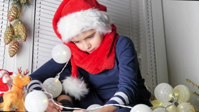 可爱的男孩戴着红帽子的圣诞孩子写信给圣诞老人，圣诞礼物愿望清单