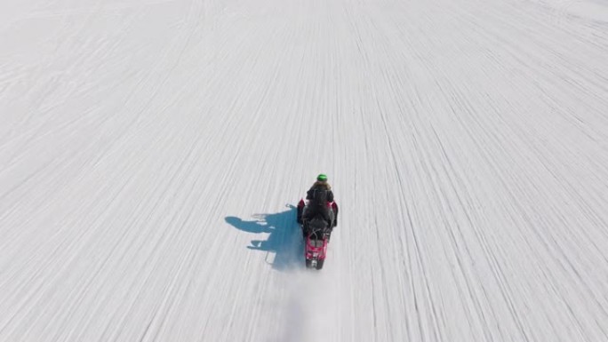 在北极骑雪地摩托的女人的无人机