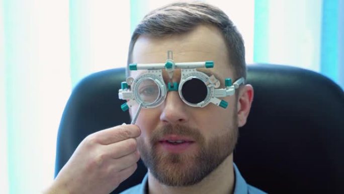 一位戴着特殊眼科眼镜的英俊男性患者。医生检查病人的视力