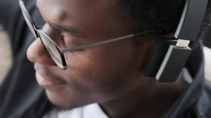 非裔美国人在耳机上听音乐的特写脸