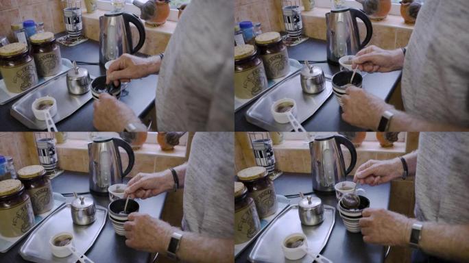 一位退休的爷爷在家里的厨房里准备热饮，手和茶。放松，喝酒，老年男性在茶杯中煮热草药，以在早餐时放松