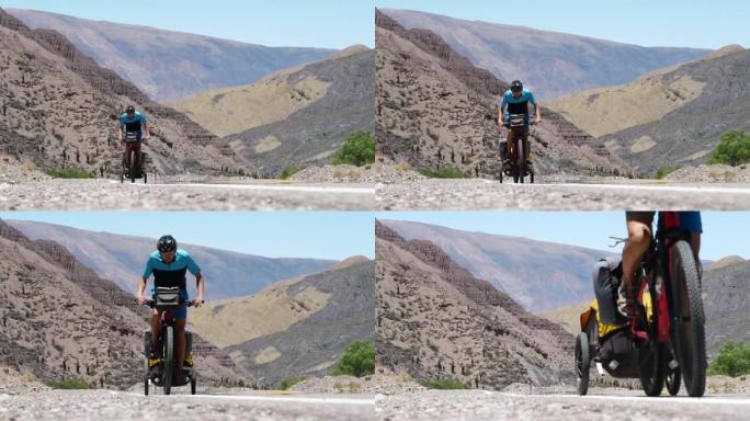 骑自行车的人骑着拖车克服了安第斯山脉的困难通行证