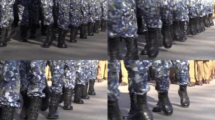 身着迷彩服的士兵们的腿在街道上行进，这是一场致敬游行