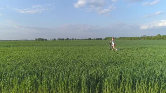鸟瞰图。一名年轻女子正在绿色的田野里锻炼步进器。