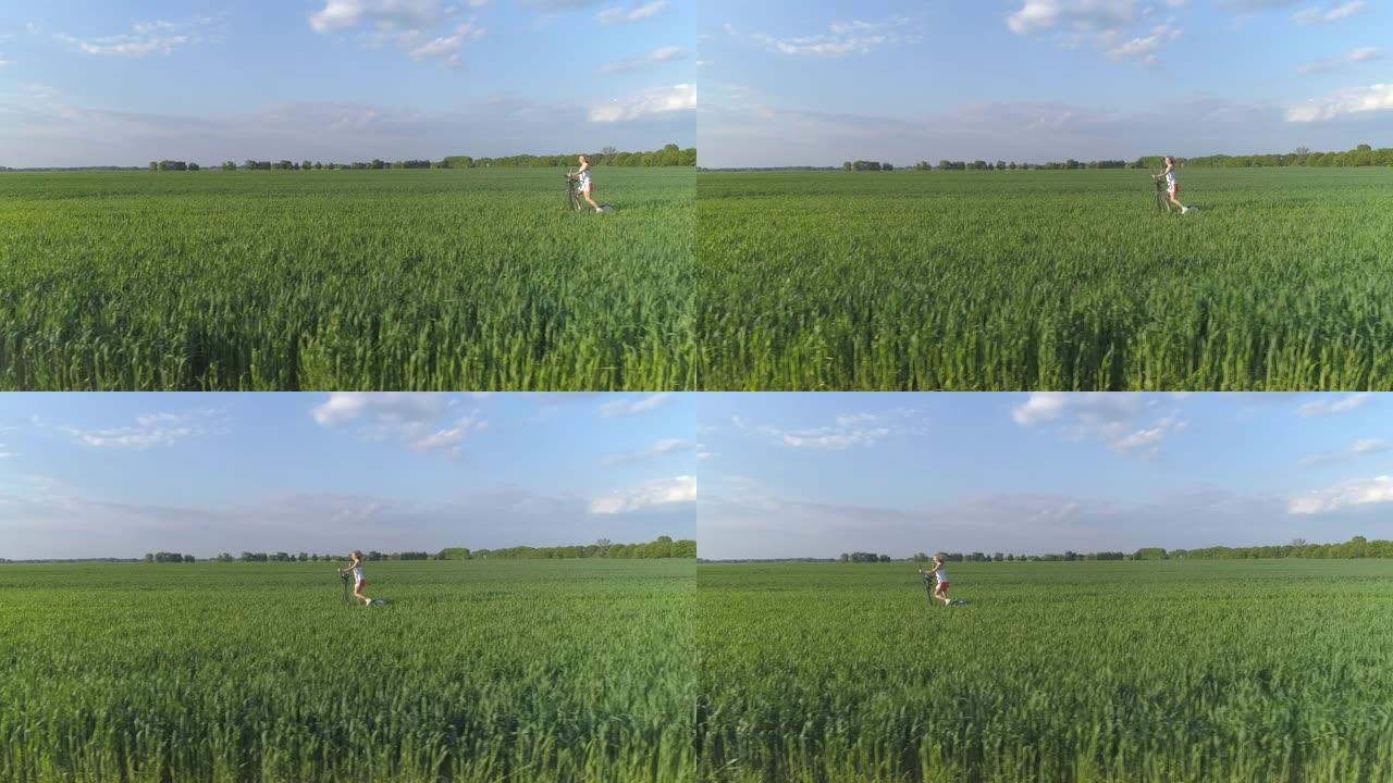 鸟瞰图。一名年轻女子正在绿色的田野里锻炼步进器。