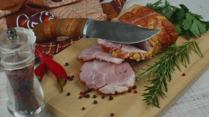 传统火腿用雕刻刀、多色多香果、红辣椒、欧芹、莳萝和罗勒切成薄片。从猪肉中吃出美味肉食小吃的概念