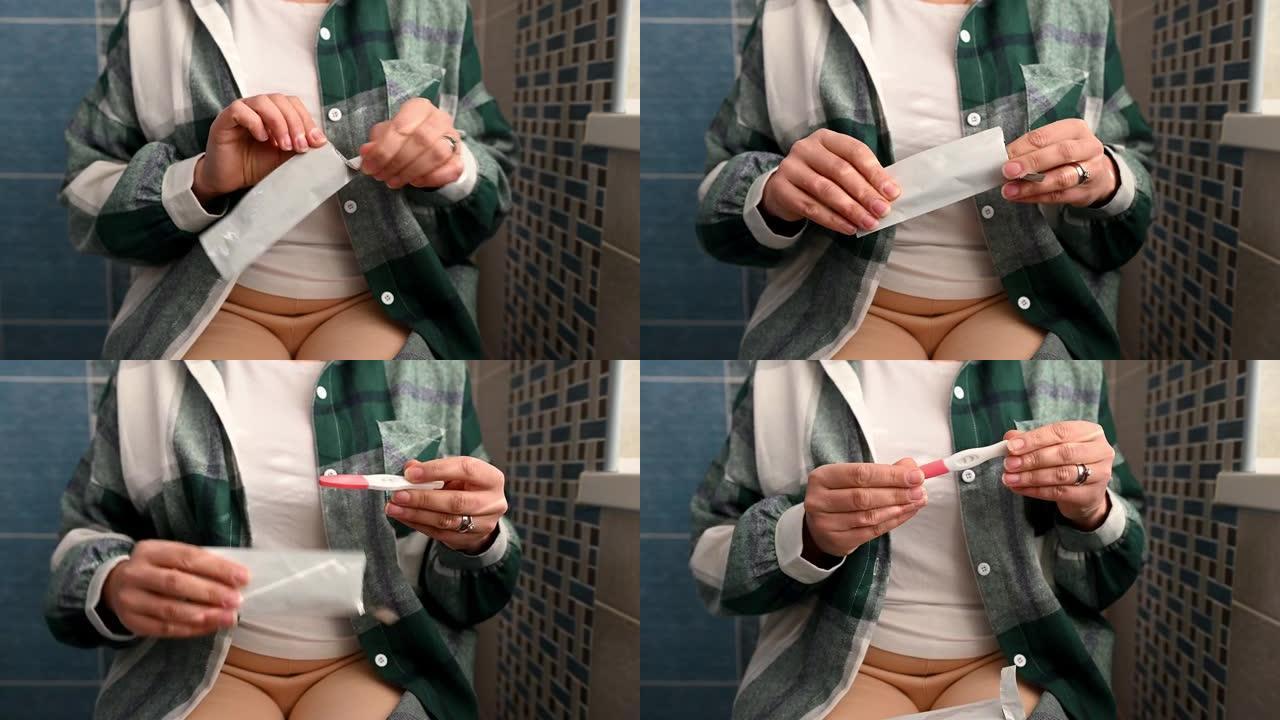 特写女人的手打开怀孕测试。孕妇和怀孕家庭诊断概念