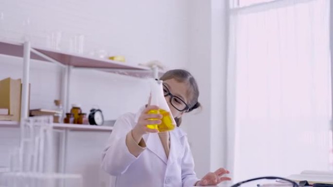4K，儿童女学生，拿着烧瓶进行化学实验，在科学课上进行实验，孩子喜欢实验，看着烧瓶玩捕捉蒸发的烟雾，
