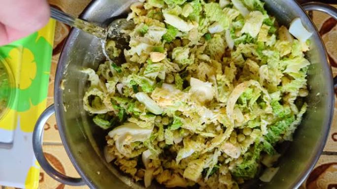 新鲜蔬菜沙拉。用勺子搅拌。萨沃伊卷心菜、鸡蛋和豌豆配香料沙拉。