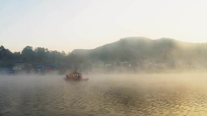 泰国北部湄宏顺班拉泰国村背景上的传统中式船，在清晨的阳光下雾蒙蒙的河水湖上日出