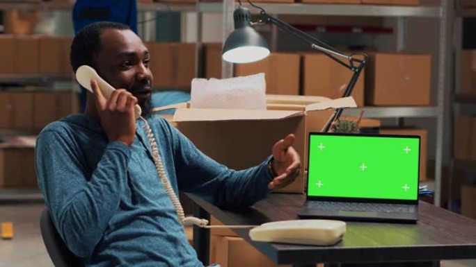 男性企业家在固定电话上交谈并在pc上使用绿屏