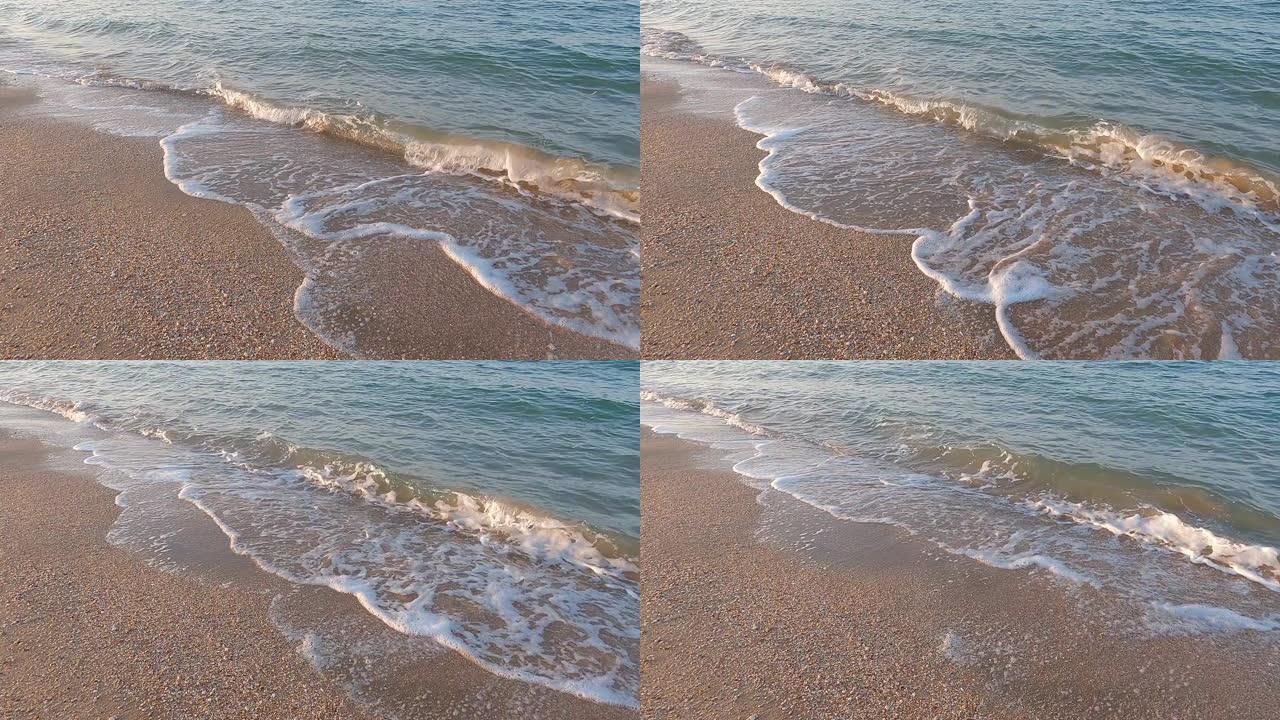 日落时在沙质海岸上冲浪，水滚入海岸，慢动作