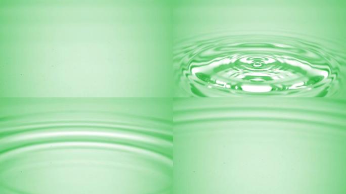 水滴落在绿色流体表面上，形成水环