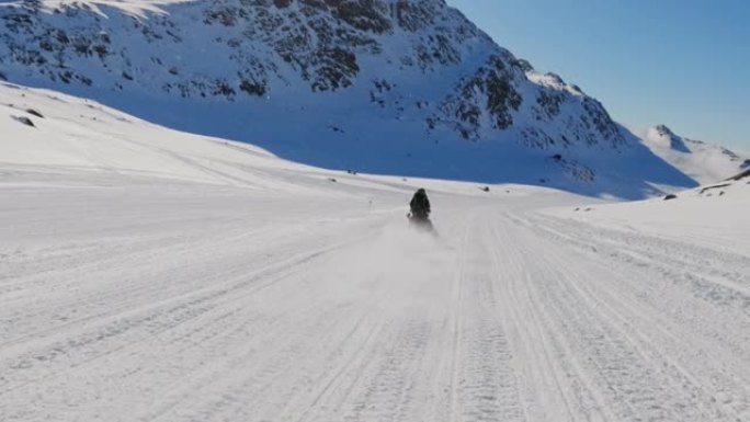 骑雪地摩托穿越北极雪的人