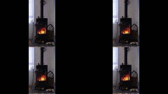 黑色炉子，阁楼风格的房子内部壁炉。替代环保供暖，家里温暖舒适的房间，燃烧木材。垂直视频