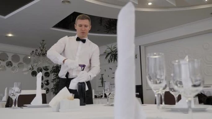 一个戴着白手套的服务员用开瓶器打开一瓶红酒的特写镜头。