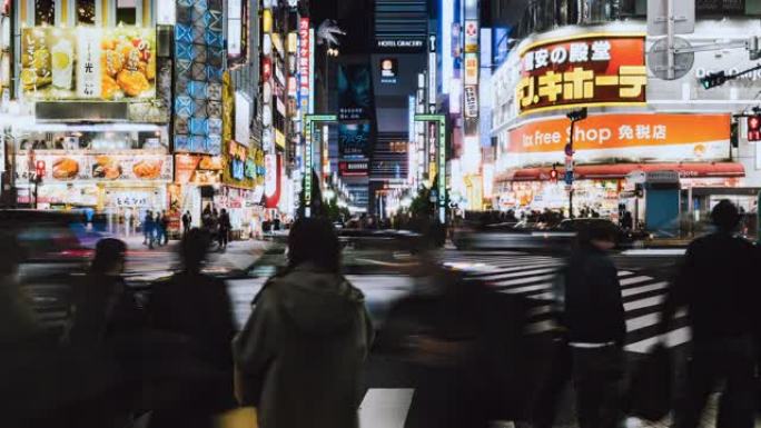 日本人的夜景，亚洲旅行者过马路，东京新宿歌舞伎町区哥斯拉街汽车交通。亚洲旅游或日本交通