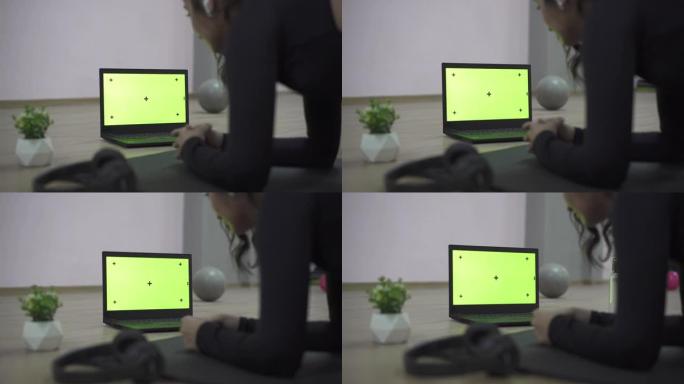 后视图妇女在使用笔记本电脑时锻炼，模拟屏幕