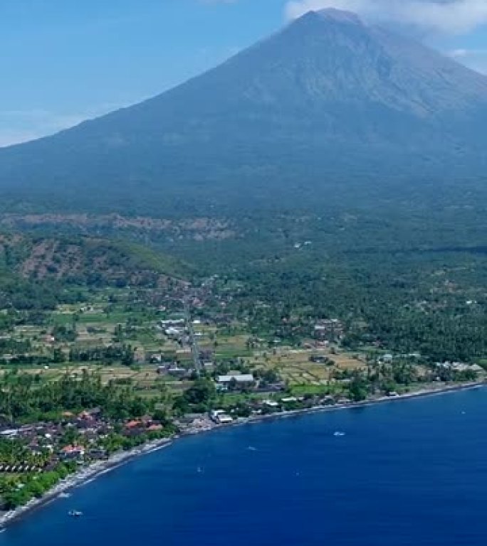 岛屿海岸的垂直视频，背景为黑沙滩和火山爆发