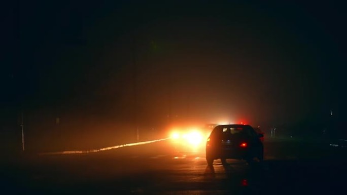 停电期间，在城市的黑暗道路上缓慢移动汽车。停电危机时期的现代城市。