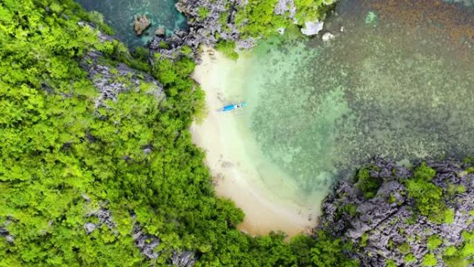 环礁和绿松石泻湖上的热带岛屿。岩石岛，白色沙滩，鸟瞰图。