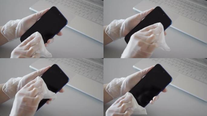 消毒防护预防、家务劳动、冠状病毒安全、卫生理念。女人清洁智能手机，手机工作场所用抗菌消毒擦拭杀死家里