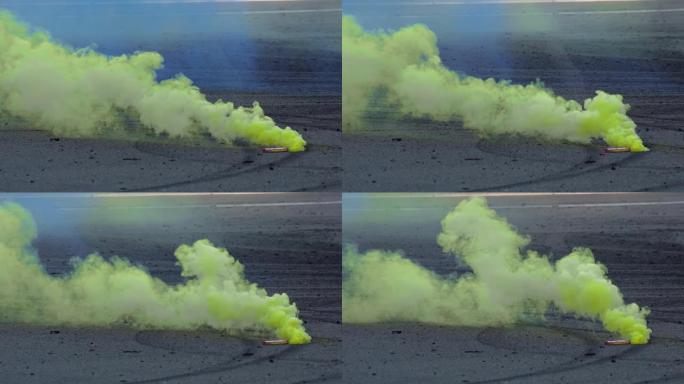 一枚彩色的黄色烟雾弹躺在沥青上，在汽车漂移比赛中冒烟。赛车锦标赛。特写。专业极限驱动