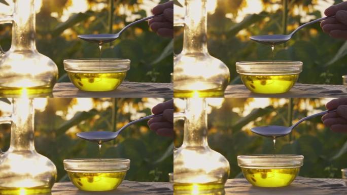 葵花籽油从汤匙流入玻璃碗。生产有机葵花籽油，瓶装油