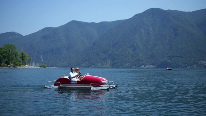 在温暖阳光明媚的夏日，男人和女人在湖上骑着划桨船