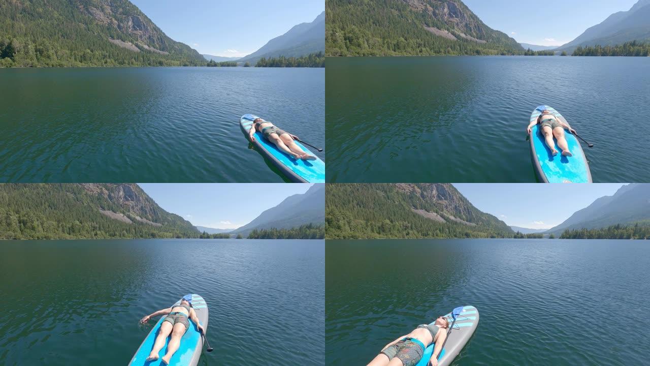 站立划桨寄宿生 (SUP) 在湖上享受宁静的时光