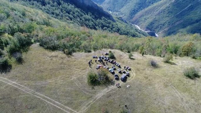 在森林的一条土路上，亚视四边形的空中无人机视图。越野团体俱乐部爱好者在驾驶乡村道路时玩得开心。