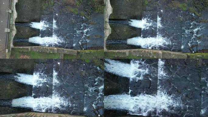 养殖鱼塘坝具有类似堰的运河安全溢流。水从一座有几个拱门的石桥下流过。桥上坝顶同，源饮、干、旱、贮