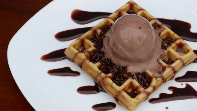 巧克力华夫饼配冰淇淋浇头和巧克力洒。4k镜头