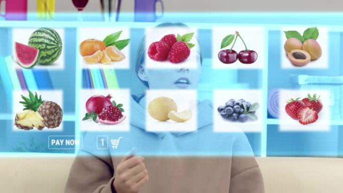 一个年轻女孩在虚拟屏幕上选择水果。