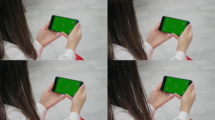 女性手在智能手机上观看色度键屏幕。